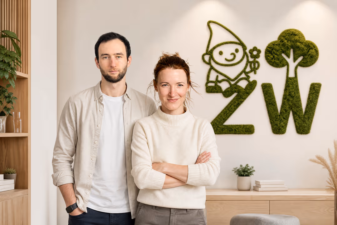 Janine & Lucien vor der Moos-Wand mit dem ZW-Zeichen in ihrem Büro